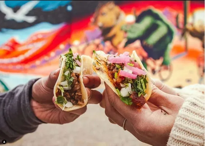 People holding tacos from Street Taco and Beer Co