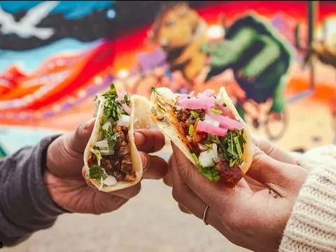 People holding tacos from Street Taco and Beer Co